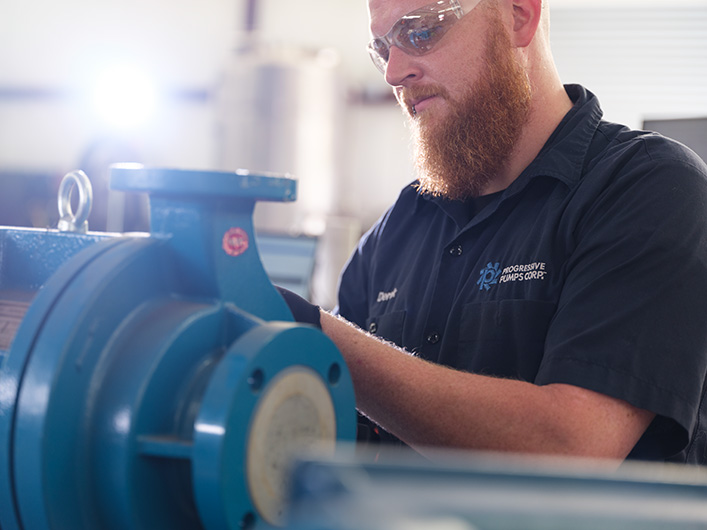 Photo of an employee repairing a pump